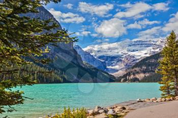The picturesque promenade at Lake Louise. The emerald waters of lake surrounded by mountains, glaciers and pine forests. Banff National Park, Rocky Mountains, Canada