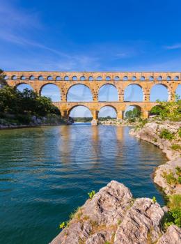 Three-storied aqueduct of Pont du Gard - the highest in Europe. The bridge was built at the time of Roman Empire on river Gardon. Provence, spring sunny day