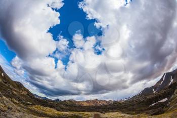 The picture was taken Fisheye lens. Travel to Iceland in July, volcanic summer tundra. Multi-colored rhyolite mountains - orange, yellow, green and blue