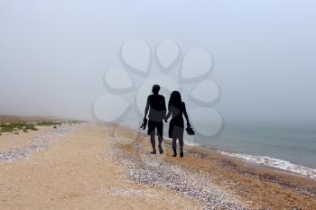 Romantic couple silhouette  walking on the beach