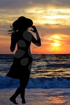 Woman on the beach looking at the sunrise