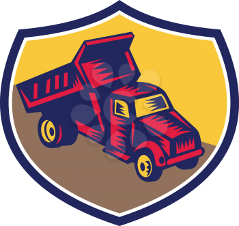 Illustration of a dump truck viewed from high angle set inside shield crest done in retro woodcut style. 