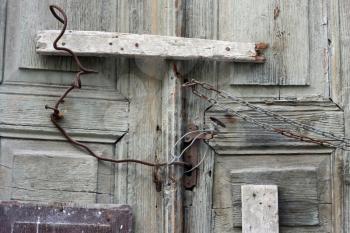Royalty Free Photo of an Old Door With Wire and Boards