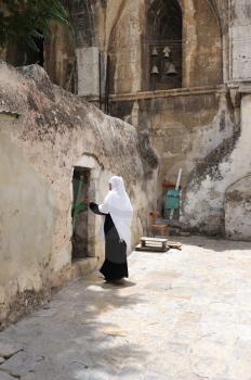 Royalty Free Photo of a Nun in Front of a Cell on the Roof of the Church of the Holy Sepulchre 