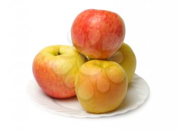 Red and yellow apples on a white plate on a white background.