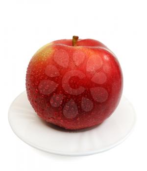 Red apple on a white plate on a white background, isolated