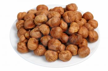 Hazelnuts on a white plate on a white background, isolated.