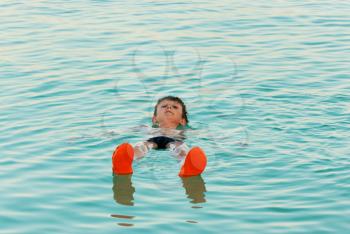 Royalty Free Photo of a Boy Lying in the Waters of the Dead Sea