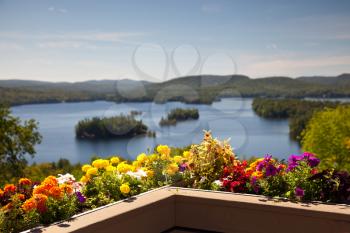Beautiful colorful view on the mountains lake from balcony with yellow and red flowers