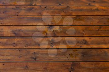Stained wet deck wooden boards with water drops, brown planks texture