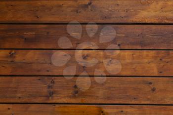 Stained wet deck wooden boards with water drops, brown planks texture