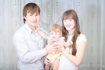 Happy family of three person together and smiling indoors