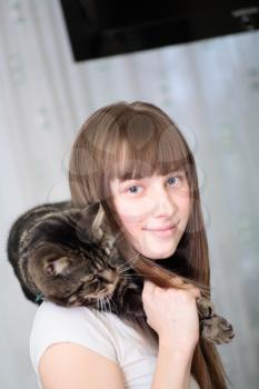Portrait of a relaxed young woman smiling indoors with cat