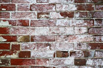 old red brick wall with some traces of former paint jobs