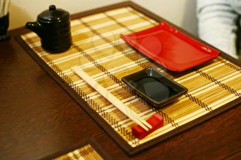 A closeup of a japanese dinner-set: plates and sticks on the table