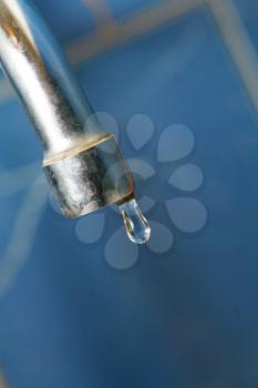 water tap closeup. Shallow depth of field, focus on the tap and the droplet