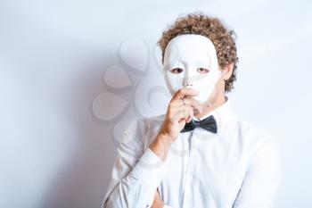 Face mime close-up emotion in thought, a black bow tie, theatrical white mask