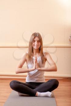 Pretty blonde women meditating in yoga studio on beige background . Mental health spiritual development concept