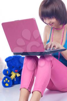 studio portrait of a sexy brunette girl on the floor with a laptop