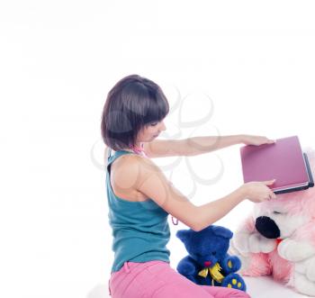 Young girl using a laptop near bear toys on white