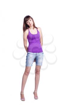 charming brunette women 20-25 years old standing in studio isolated on the white background. Violet tank top, jeans shorts