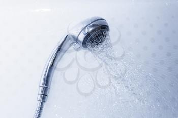 water flowing from the shower head. Shower and flying water drops.