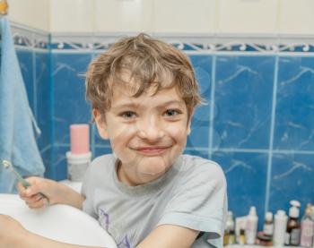 kid brushing teeth in a bathroom.
