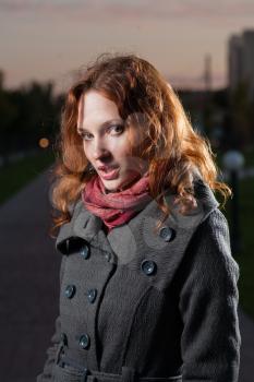 redhead 20s women outdoor, head and shoulders portrait, in autumn park, weared scarf and coat. Vertical shot.