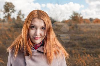 carrot-top women head and shoulders shot smiling and enjoy the autumn