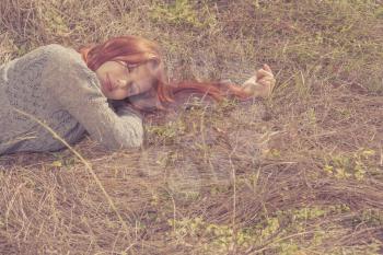 red haired women lying on autumn grass