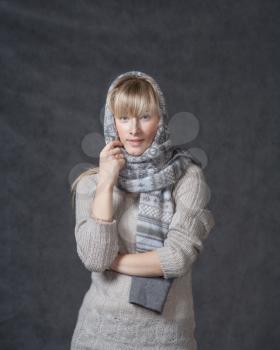 Portrait of woman on dark background wearing woolen accessories