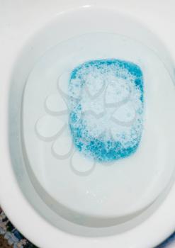 Sanitary background. Toilet bowl closeup with blue water