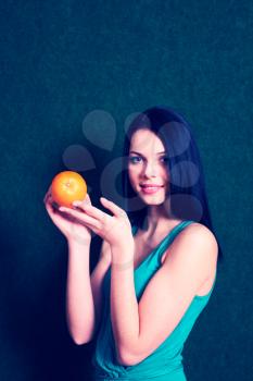 female with an orange in her hands, cross processed colors, vintage looking image