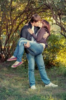 Young happy attractive couple kissing, outdoors