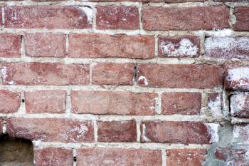 The old red brick wall. Red brick wall closeup background. It depicts an old brick wall crumbling