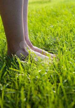 Legs on the grass. Foot in the grass.