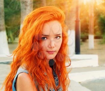Closeup shot of a pretty red haired women in calm state looking at camera crossprocessed colors