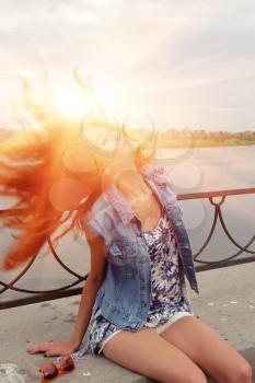 Redhead women with sun in her beautyful hairs. Summertime freedom and happyness.