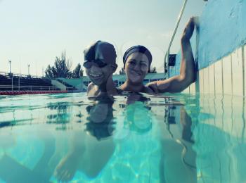Son and mom in pool having fun together a lot of copyspace toned image