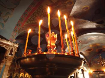 Astrakhan Russia - 10 October 2020: Orthodox chirch inside view with many burning candles on golden stand, view from below, city of Astrakhan, Russia