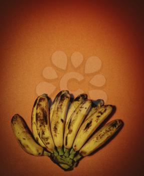 Bunch of bananas on red background with vignette and copyspace. Fresh organic Banana overripe, Fresh bananas on kitchen table. Retro colour