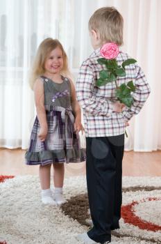 Royalty Free Photo of a Little Boy Giving a Girl a Flower
