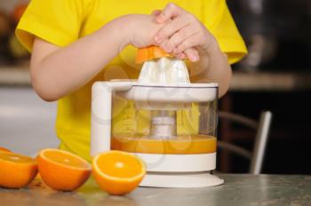 Royalty Free Photo of a Child Using a Juicer