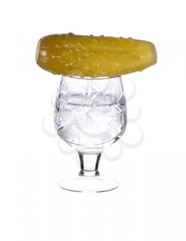 Vodka in a wineglass and pickled a cucumber isolated on white background