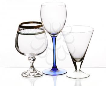 Three transparent empty glasses stand on a table