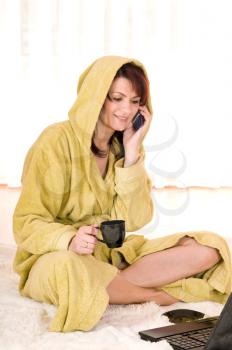 Woman in robe with laptop sitting on the floor