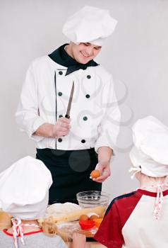 Chef is teaching kids to cook on the grey background