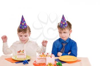 two thoughtful boys with a cake isolated on white background