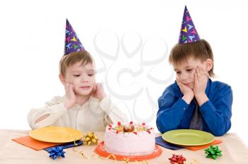 two thoughtful boy with a cake isolated on white background