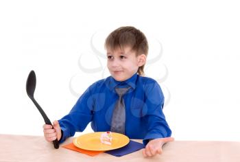 child with a large spoon is going to eat cake isolated on white background